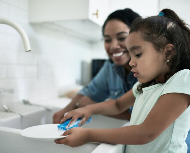 Stock photo mother and daughter at sink washing dishes